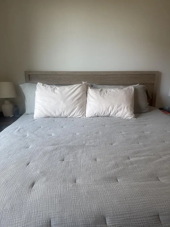 Made bed with white pillows and a gray comforter