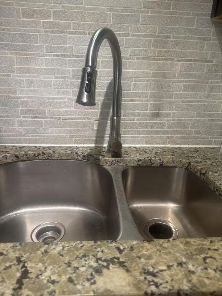 Stainless steel double kitchen sink with a pull-down faucet