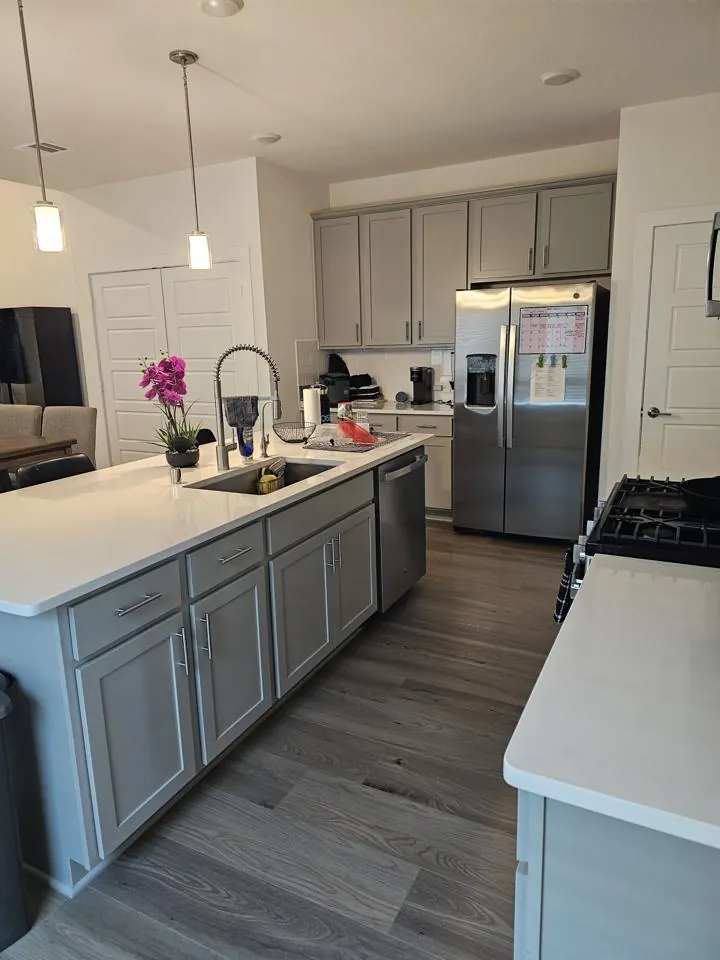 Kitchen with an island, sink and stainless steel refrigerator